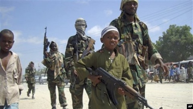 A young boy leads the hard-line Islamist Al Shabab fighters as they conduct military exercise in northern Mogadishu's Suqaholaha neighborhood, Somalia (File Photo)