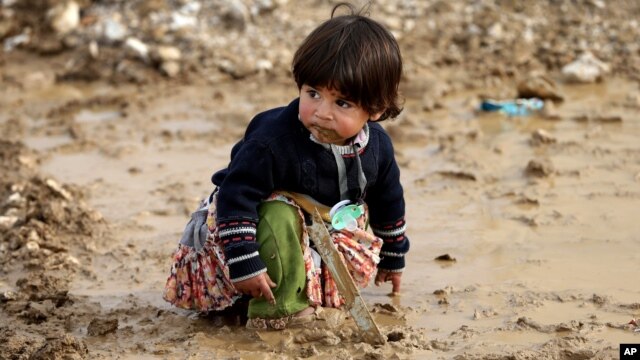 Một bé gái tị nạn Syria ngồi trên đống bùn tại một trại tị nạn ở thị trấn Al-Faour, miền đông Libăng.