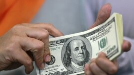 A woman counts her U.S. dollar bills at a money changer in Jakarta June 13, 2012. Indonesia's central bank sold $700 million of its first dollar-denominated term deposits on Wednesday, in an effort to relieve a local scarcity of the U.S. currency. Bank In