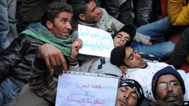 Tunisian protesters who walked from Sidi Bouzid, lay on the ground in front of the prime minister building in Tunis, 23 Jan 2011