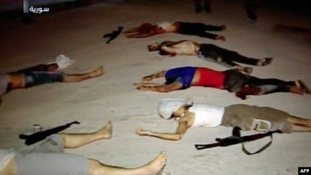 An image grab taken from a broadcast on Syrian television on July 20, 2012, shows dead men lying on the ground next to weapons in the Teshrin neighborhood of the Qabun area in Damascus. (AFP Photo / Ho / Shaam News Network)