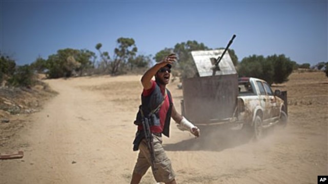 A rebel fighter gives orders to comrades at the front line between the rebels and Moammar Gadhafi forces, 25 km west from Misrata, Libya, May 26, 2011