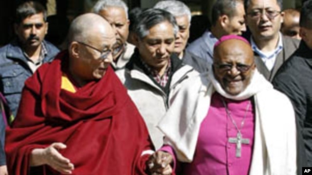 Tibetan spiritual leader Dalai Lama (L) and South African Archbishop and Nobel Laureate Desmond Tutu walk visiting a Tibetan temple in Dharamsala, India, February 10, 2012.