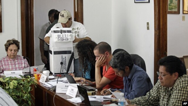 Election officials and party representatives begin the computation of ballot boxes at an electoral institute district council in Mexico City, July 4, 2012. 