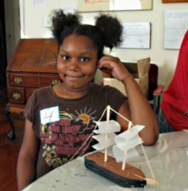 Children who visit the Amistad exhibit make their own version of the ship, which includes outlines of the chained slaves inside the hull.