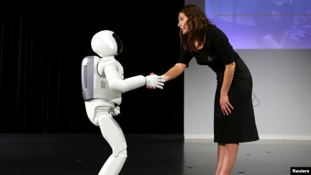 Phiên bản mới nhất của robot Asimo bắt tay sau một buổi ra mắt ở Zaventem, gần Brussels, tháng 7, 2014.