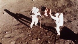 Apollo 11 astronauts Neil Armstrong and Edwin "Buzz" Aldrin, the first men to land on the moon, plant the U.S. flag on the lunar surface on July 20, 1969
