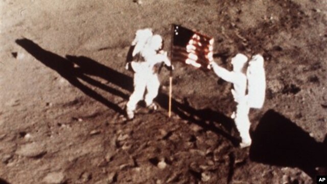 Apollo 11 astronauts Neil Armstrong and Edwin "Buzz" Aldrin, the first men to land on the moon, plant the U.S. flag on the lunar surface on July 20, 1969