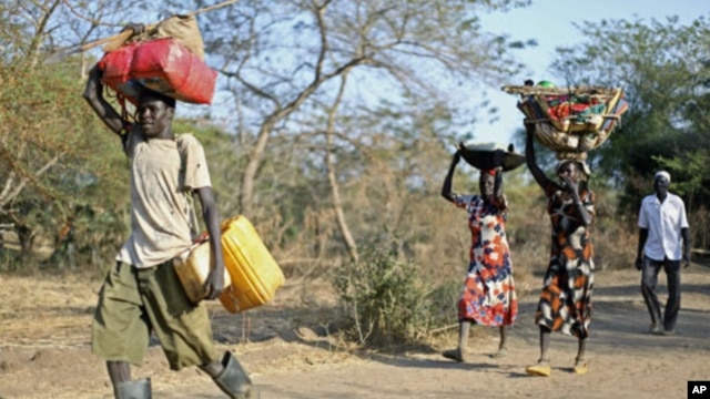 A Sudanese family from the war-torn Blue Nile state carry their belongings on their heads as they arrive at South Sudan's Doro refugee camp December 12, 2011.