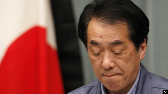 Japan's Prime Minister Naoto Kan in front of the Japanese flag with a black mourning cloth during a news conference at his official residence in Tokyo, March 25, 2011.