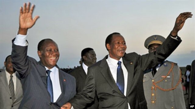 Ivory Coast President Alassane Ouattara (L) greets president Blaise Compaore of Burkina Faso at Yamoussoukro airport, a day ahead of his inauguration, May 20, 2011