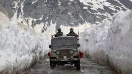 Indian army soldiers travel in a vehicle on a mountainous road covered by snow after the Srinagar-Leh highway was opened to traffic in Zojila, 108 km (67 miles) east of Srinagar April 25, 2012. The 443 km (275 miles) long highway was opened by Indian army