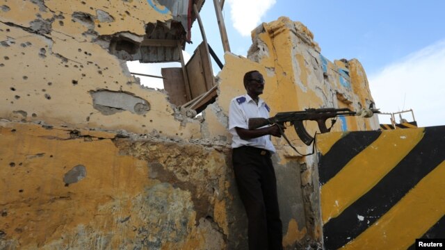 FILE - A Somali traffic policeman stands guard near the scene of a suicide car bomb explosion outside the traffic police headquarters in Somalia's capital Mogadishu. Abukar Arman, the former Special Representative of Somalia to Washington, said Wednesday the United States has been weak in using “soft power” in its effort to support the government attain security and political stability.
