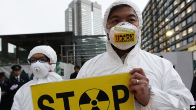 A Greenpeace activist holds a placard during a demonstration outside Japan's Prime Minister Yoshihiko Noda's official residence in Tokyo, criticizing the government's declaration of cold shutdown at the Fukushima nuclear power plant, December 16, 2011.