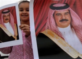 A girl holds up a picture of Bahrain's King Hamad bin Isa Al Khalifa in Muharraq, Bahrain, February 16, 2011, during a gathering to counter three days of anti-government demonstrations