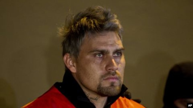 Suspended first-division soccer goalkeeper Omar 'El Gato' Ortiz, arrested for alleged participation in a kidnapping ring, is guarded by state police during a presentation to the press in Monterrey, Mexico, January 7, 2012.