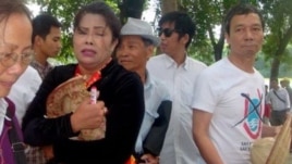 Chị Bùi Thị Minh Hằng ôm chiếc nón 'Hoàng Sa-Trường Sa-Việt Nam' sau cuộc giằng co với lực lượng đeo băng đỏ