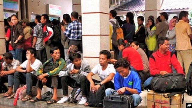 Crowds of people wait for trains to arrive before they can make hour-long journeys back to their hometowns.