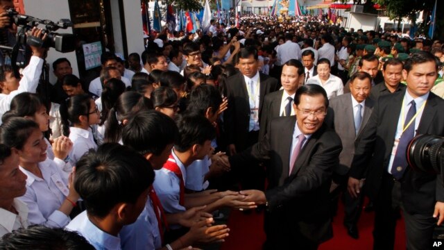 Cambodian Prime Minister and President of Cambodian People's Party Hun Sen, second right in front, greets his supporters after an event by his ruling party to mark the 37th anniversary of the 1979 downfall of the Khmer Rouge regime at the party headquarters in Phnom Penh, Cambodia, Thursday, Jan. 7, 2016. (AP Photo/Heng Sinith)