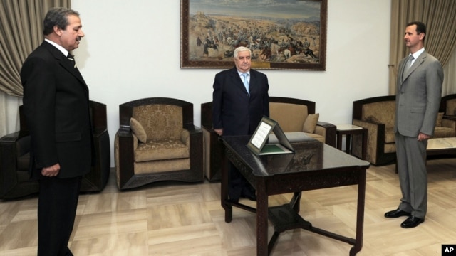Nawaf Fares, left, is sworn in as Syria's ambassador to Iraq before President Bashar al-Assad, right, and Foreign Minister Walid Moallem in Damascus, September 16, 2008.