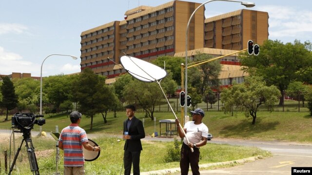 A television crew films outside a military hospital where former South African president Nelson Mandela is hospitalized in Pretoria, December 9, 2012. 