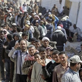 People who used to work in Libya and fled the unrest in the country, wait to receive clothes, at the Tunisia-Libyan border, in Ras Ajdir, Tunisia, Mar 3 2011