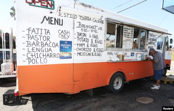 A voter registration sign is seen on a taco truck, as part of the U.S. Hispanic Chamber of Commerce's "Guac the Vote" campaign, in Houston, Texas, Sept. 29, 2016.