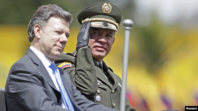 El director de la policía colombiana, José Roberto León, saluda desde un auto militar, mientras acompaña al presidente Juan Manuel Santos.