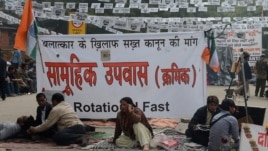Protestors sits in front of a banner during a protest against last month's gang rape and murder of a student, in New Delhi, February 2, 2013.