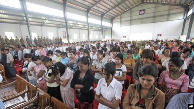 Released prisoners stand up before Burma's prison department chief Zaw Win speaks in a hall at Insein Prison in Rangoon, May 17, 2011.
