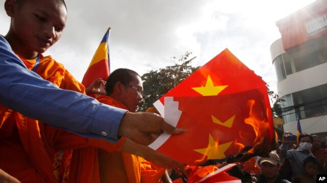 Người biểu tình Campuchia đốt cờ Việt Nam bên ngoài Đại sứ quán Việt Nam ở thủ đô Phnom Penh hồi cuối năm 2014. 