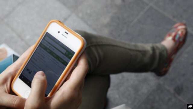In Seoul, woman surfs the Web on an Apple iPhone. The 4S model is about to go on sale in China and other countries, June 2011 (file photo).