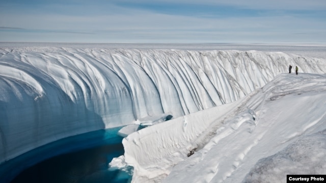 Surface melt water rushes along the surface of the Greenland Ice Sheet through a supra-glacial stream channel. [Image courtesy of Ian Joughin]