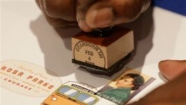 A postal service employee prepares to cancel the Rosa Parks' 100th birthday commemorative postage stamp at The Henry Ford museum in Dearborn, Mich., Monday, Feb. 4, 2013.