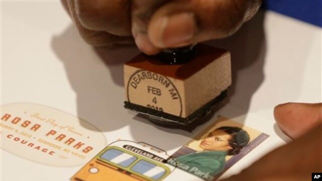 A postal service employee prepares to cancel the Rosa Parks' 100th birthday commemorative postage stamp at The Henry Ford museum in Dearborn, Mich., Monday, Feb. 4, 2013.