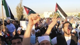 Jordanians and Syrian refugees protest the killing of at least 108 people in the Syrian town of Houla last Friday, outside the Syrian embassy in Amman, Jordan, May 30, 2012. 