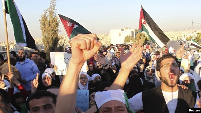 Jordanians and Syrian refugees protest the killing of at least 108 people in the Syrian town of Houla last Friday, outside the Syrian embassy in Amman, Jordan, May 30, 2012. 