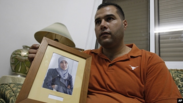 Palestinian Mohammed Tamimi holds a picture of his sister Ahlam Tamimi, held in an Israeli jail, during an interview in the West Bank city of Ramallah, October 16, 2011.