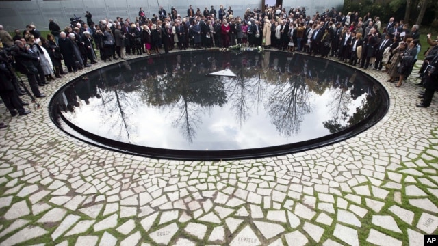People attend the inauguration ceremony at the memorial to the murdered European Sinti and Roma who were persecuted as 'Gypsies' in Berlin, October 24, 2012.