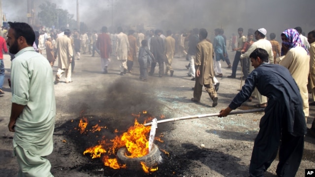 Pakistani protesters burn tires to block the main highway in Rawalpindi, Pakistan, September 21, 2012.