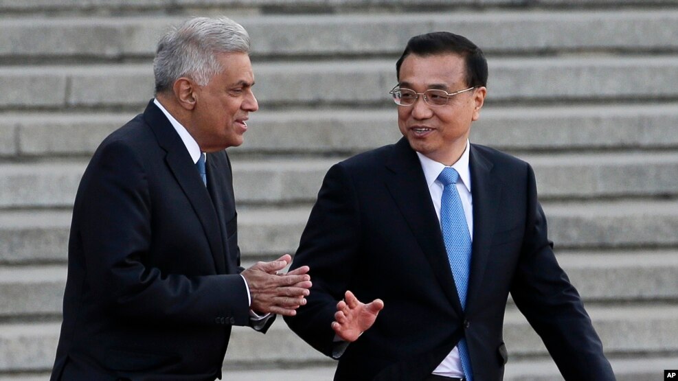 Sri Lanka's Prime Minister Ranil Wickremesinghe, (l) chats with Chinese Premier Li Keqiang during a welcome ceremony outside the Great Hall of the People in Beijing, April 7, 2016.