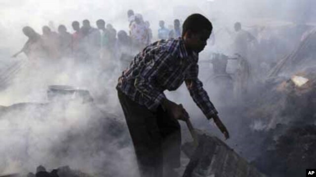 Mtu mmoja akipekua mabaki katika shambulizi la sokoni huko Hamaerweyne wilaya ya kusini mwa  Mogadishu January 26, 2012. REUTERS/Feisal Omar (SOMALIA - Tags: DISASTER ENVIRONMENT BUSINESS)