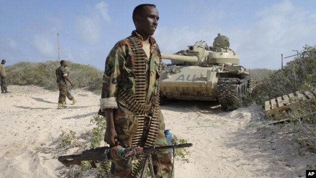 A Somali government soldier holds his weapon in the port of El-Ma'an a few hours after Somali and African Union forces ousted al-Shabab fighters from the area 32km northeast of Mogadishu, Somalia, Sept. 4, 2012. Elsewhere, the Kenyan Navy shelled Somalia's port town of Kismayo, the remaining stronghold of the al-Qaida-linked militants, in preparation for ground forces to capture the town. 