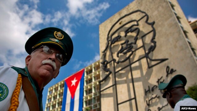 Thành viên của ban nhạc quân đội đứng dưới tác phẩm điêu khắc bằng sắt của Ernesto "Che" Guevara tại Quảng trường Cách mạng ở Havana, Cuba.