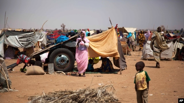 This photo taken March 9, 2014 and released by the United Nations African Union Mission in Darfur (UNAMID) shows a family at the Kalma refugee camp for internally displaced people, south of the Darfur town of Nyala, Sudan.