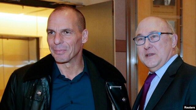 French Finance Minister Michel Sapin (R) and Greek Finance Minister Yanis Varoufakis pose before a meeting at the Bercy Finance Ministry in Paris, Feb. 1, 2015. 