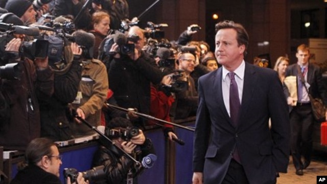 British Prime Minister David Cameron, center, speaks with the media as he arrives for an EU summit in Brussels, Dec. 8, 2011.