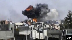Smoke billows an impact following purported shelling in Khaldiyeh district, Homs, Syria. (file)