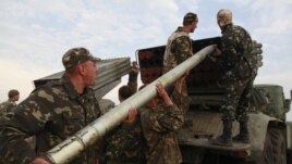 Ukrainian soldiers load a Grad missile during fighting with pro-Russian separatists close to Luhansk, eastern Ukraine, Aug. 18, 2014.