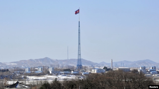 A giant North Korean flag flutters on the top of a tower in the propaganda village of Gijeongdong, North Korea, seen from South Korea, near the border village of Panmunjom, Feb. 15, 2013.